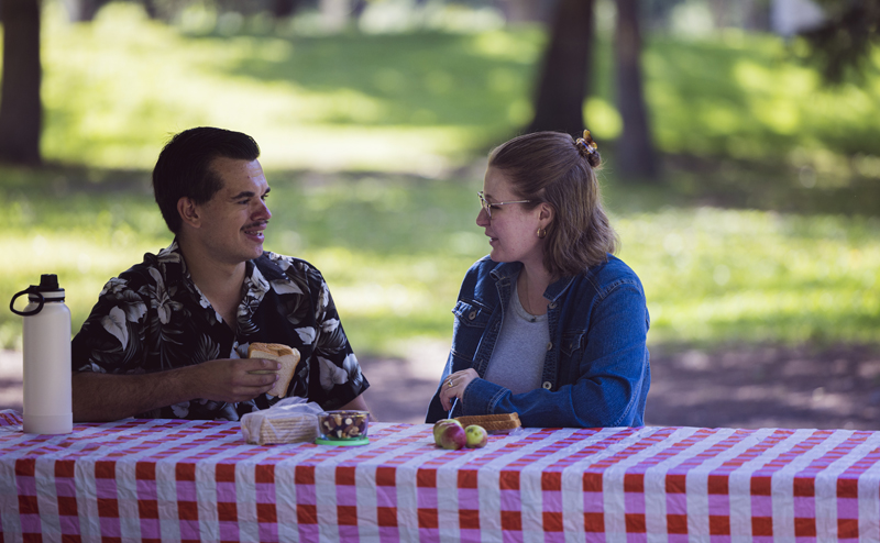 Two people sitting at a picnic bench