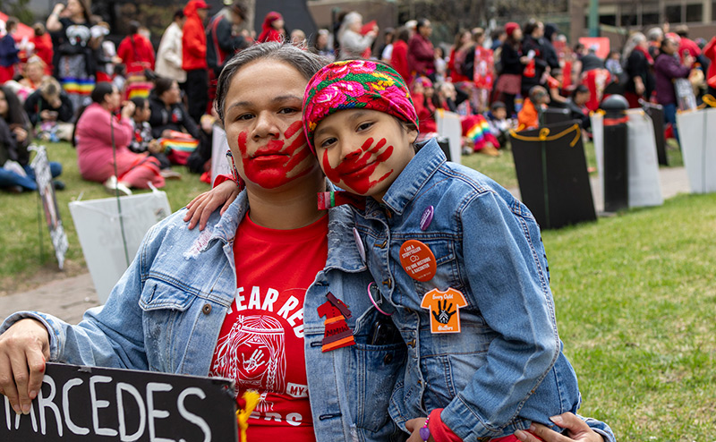 two persons at red dress day event