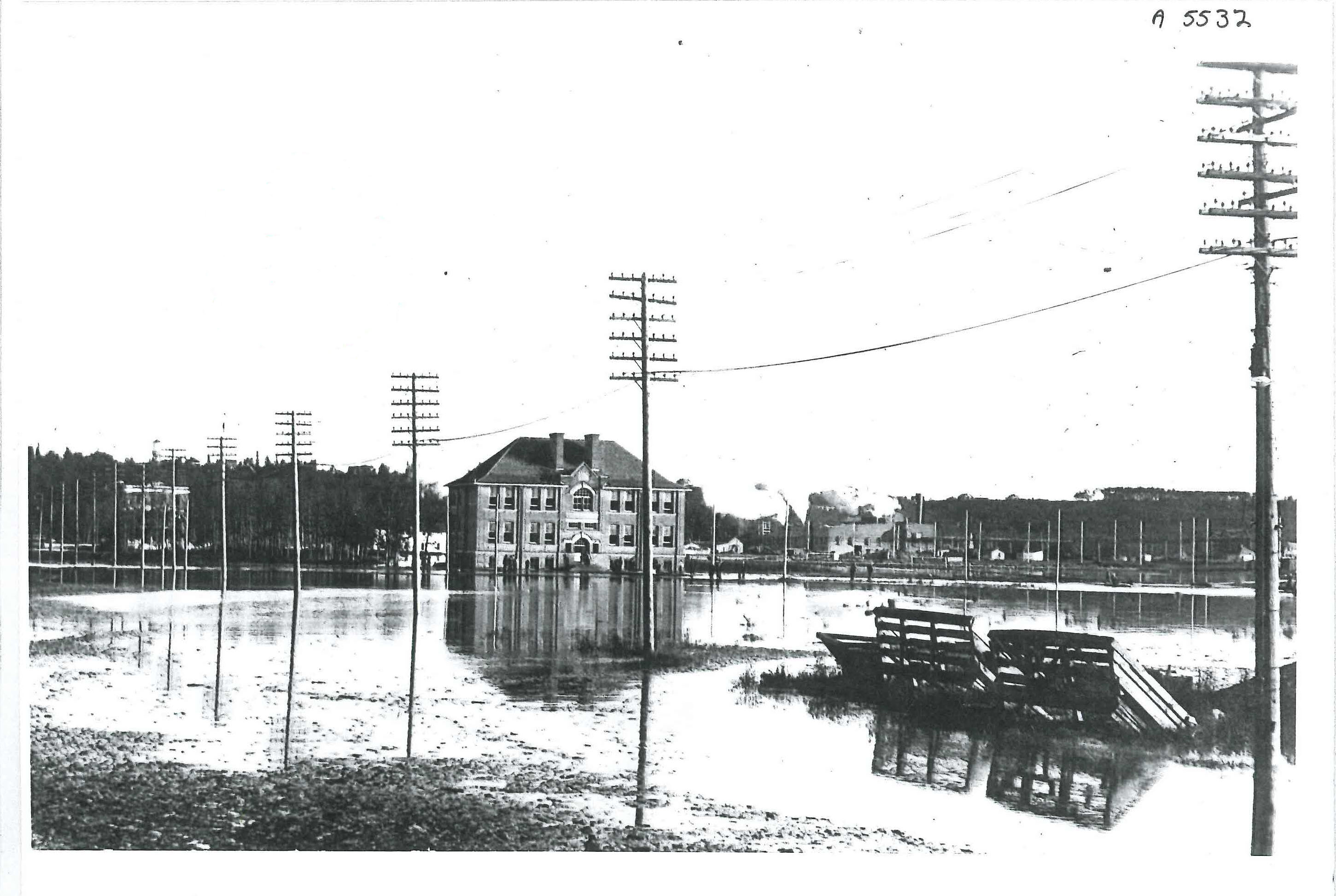 Donald Ross School during the 1915 Flood. The Ross Flats Apartments and the Rossdale Power Plant are in the background. 
