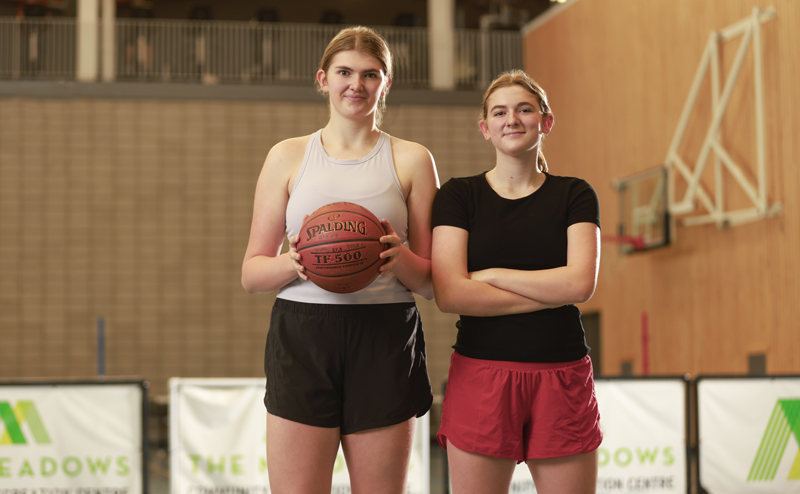 Two women in a gymnasium at The Meadows. One is holding a basketball.