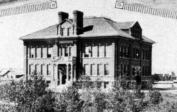 Black and white photo. Multi-story school building.
