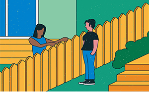 A lady talking to a neighbour over a fence.