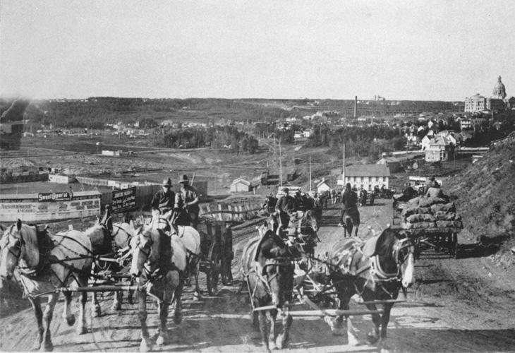 Black an white photo of men riding horse-pulled carriages on McDougall Hill.