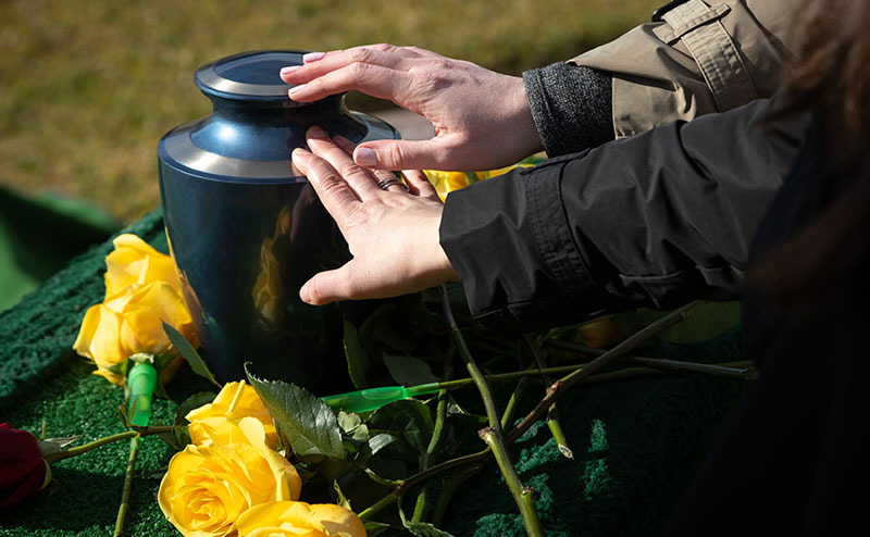 hand on urn with flower