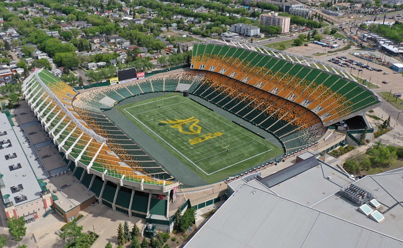 Colour aerial photo of Commonwealth Stadium during the day. The Edmonton Elks team emblem is painted on the field.