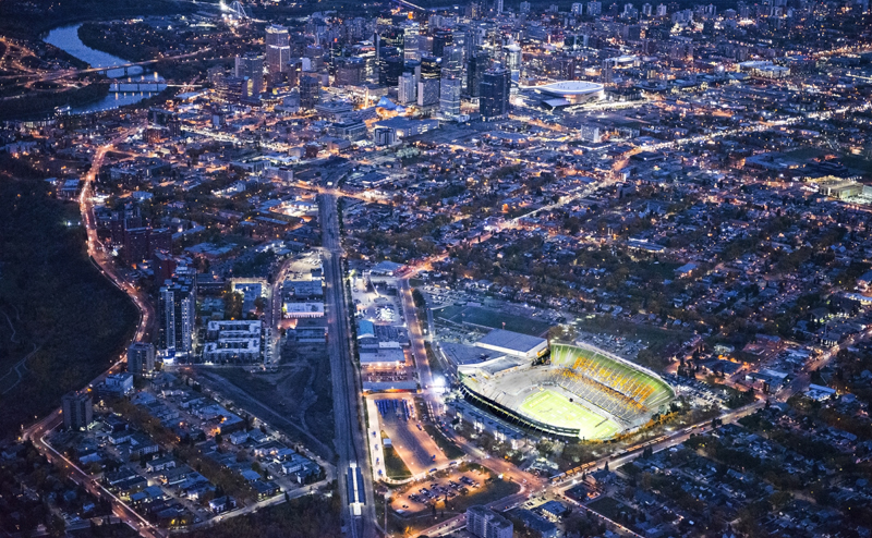 Aerial photo of Edmonton, showing Commonwealth stadium brightly lit amongst the other buildings.