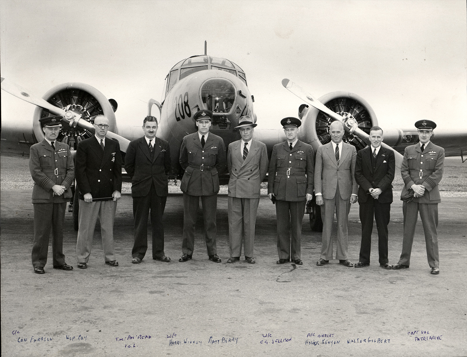 No. 2 AOS and Canadian Airways staff posing in front of the nose of an airplane