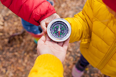 kids hands with compass