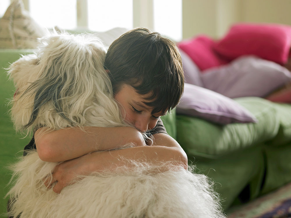 child hugging dog