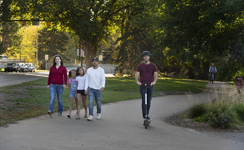 Family walking on shared use path with scooter and cyclist