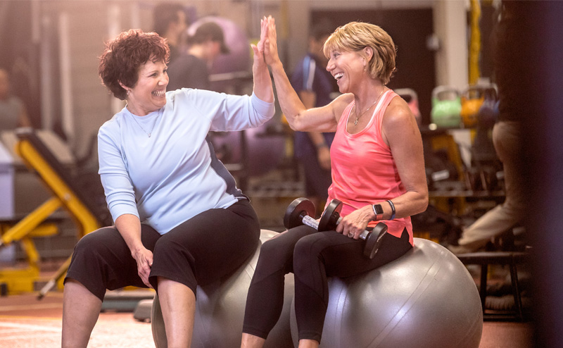 Two women high fiving at gym