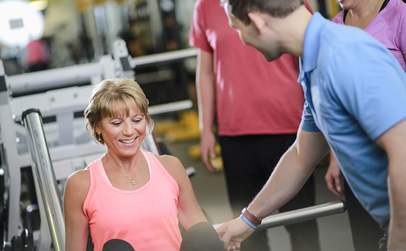 A woman using weight lifting equipment.