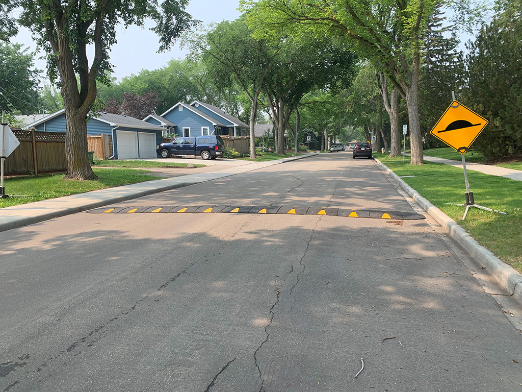 view of street with rubber speed hump and sign beside it