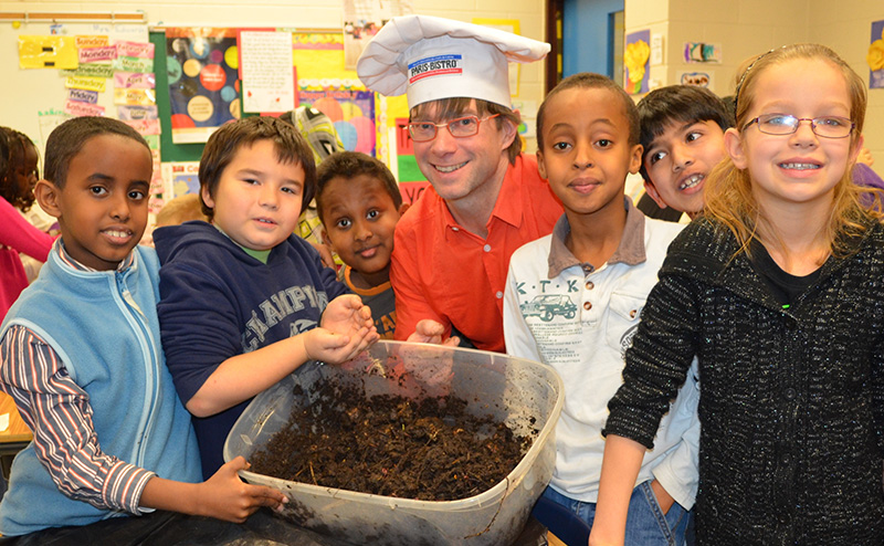 Children and instructor in a class room with a worm bin