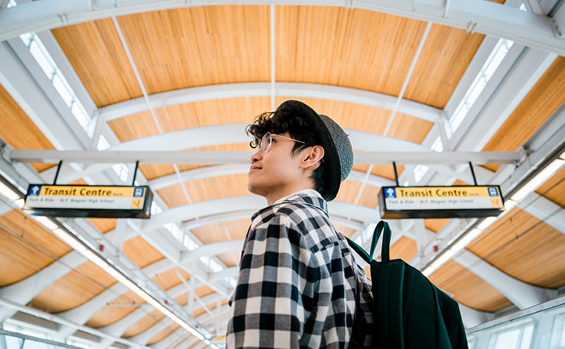 Young person looks at transit signs in LRT