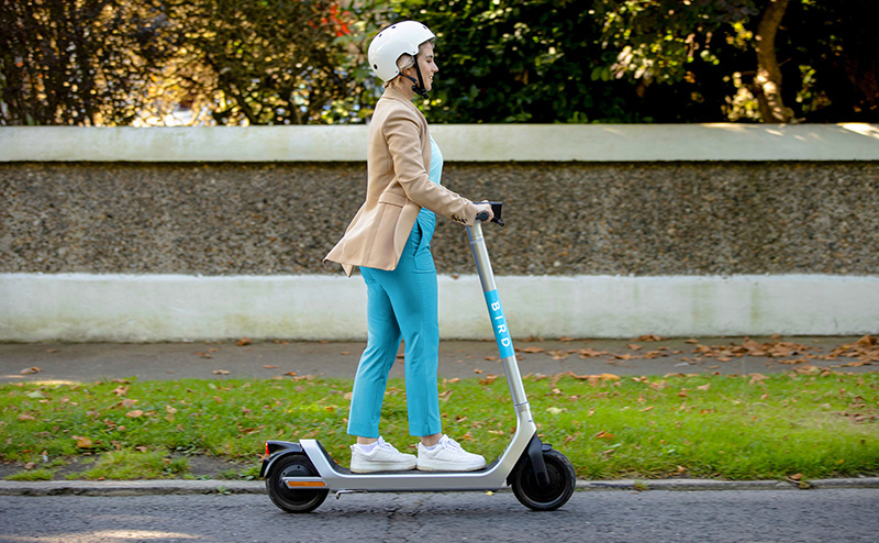 Woman riding a Bird e-scooter