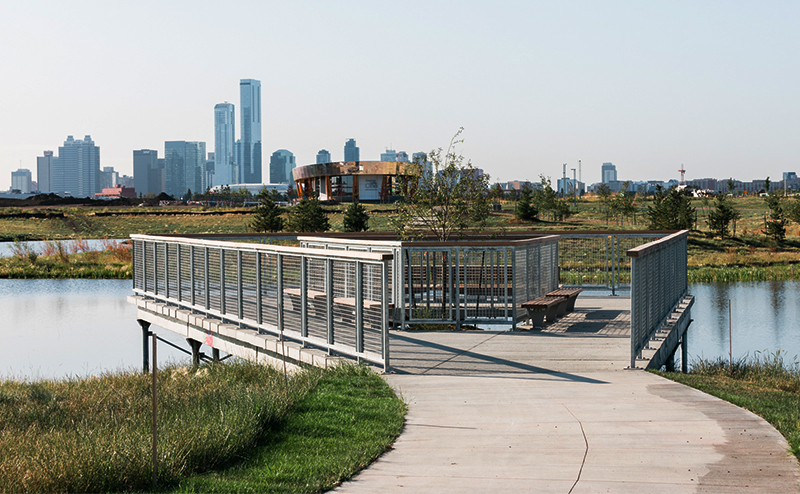 Photo of Blatchford pond with the city skyline in the background.