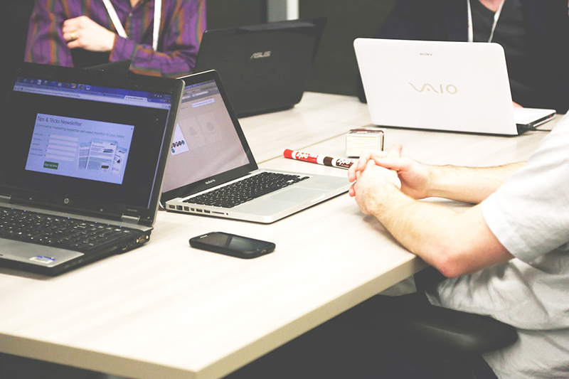 Close up of a group of people collaborating using their laptop computers