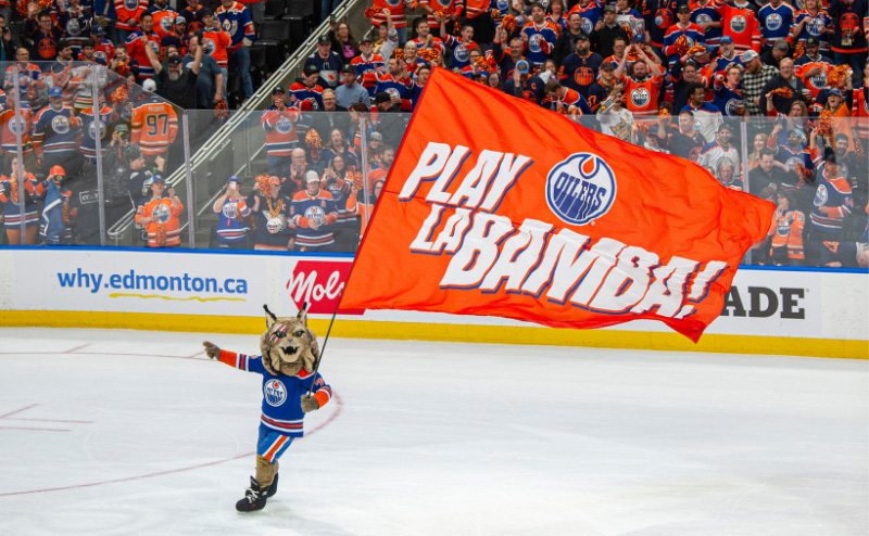 Oilers mascot skating with Play La Bamba flag