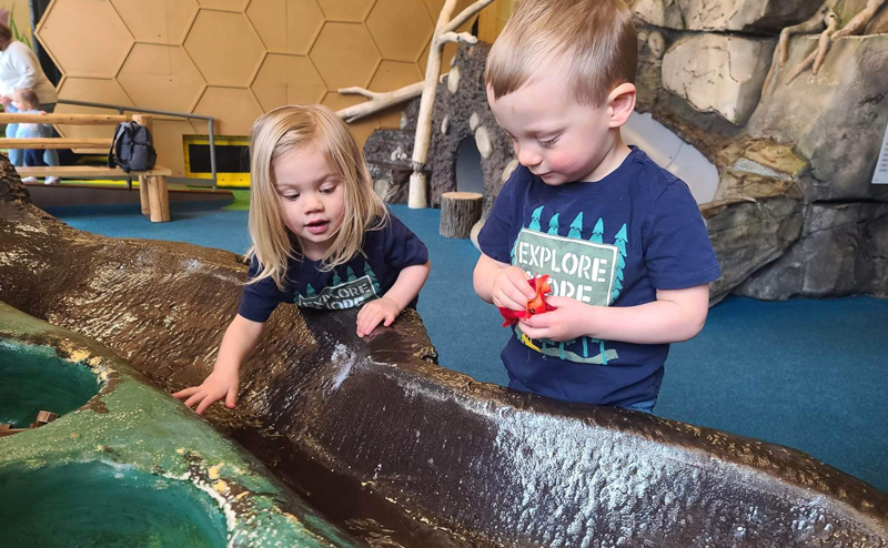 Two young children enjoying a display at John Janzen Nature Centre.