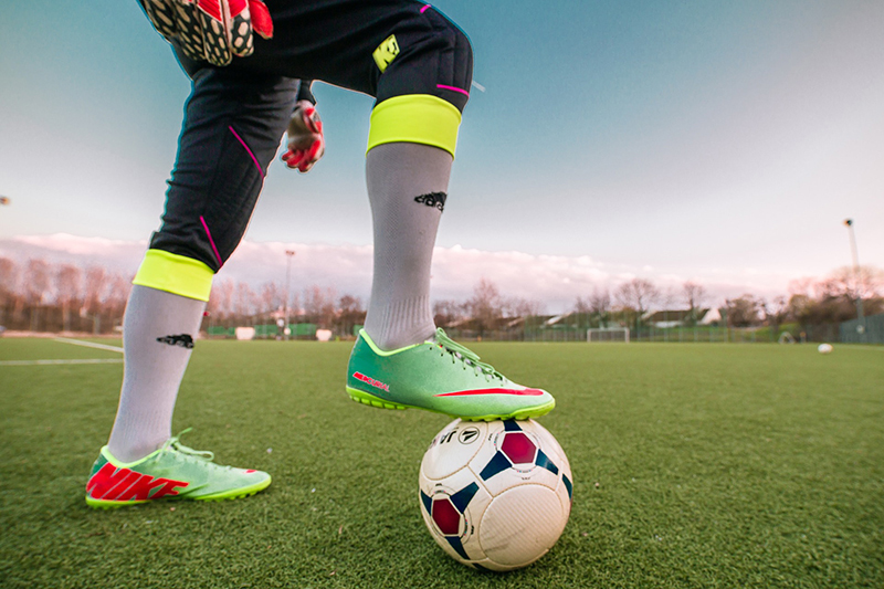 Soccer player posing with their foot on the ball