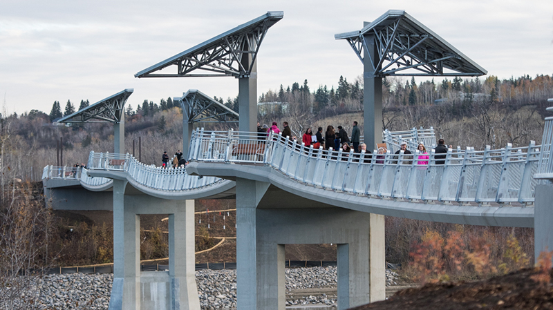 View of the bridge with several people on it from shore