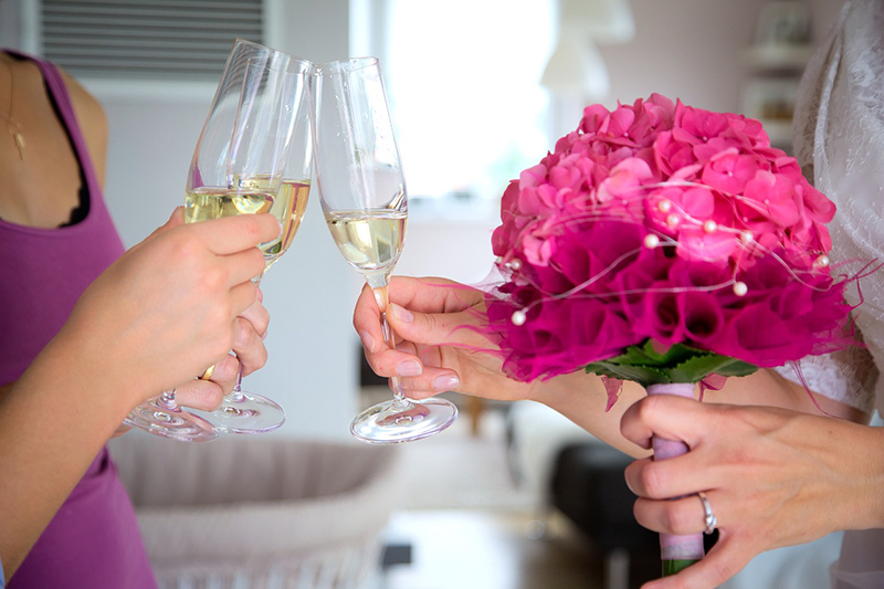 Two people at a wedding toasting with champagne glasses