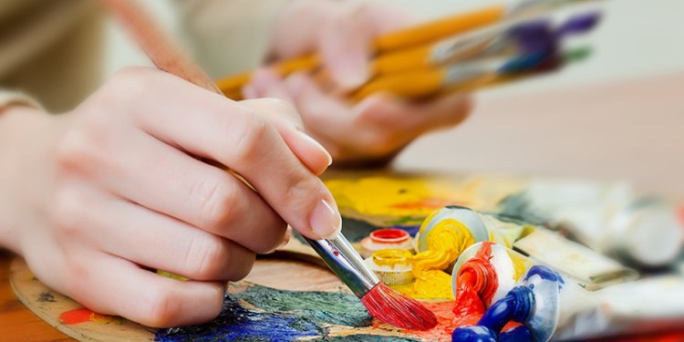 hand with paint supplies