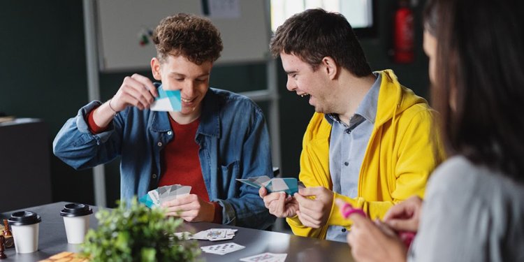 two persons of diverse abilities playing cards
