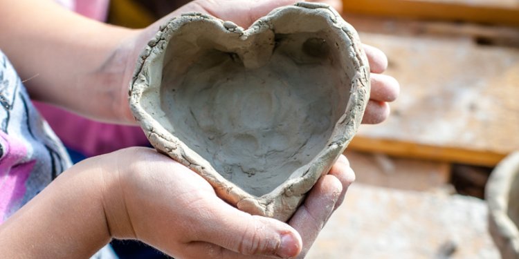 person holding a clay heart