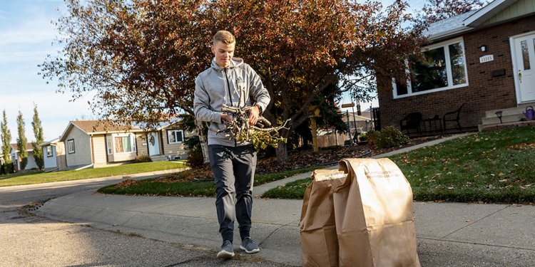 man setting out yard waste with twigs and branches