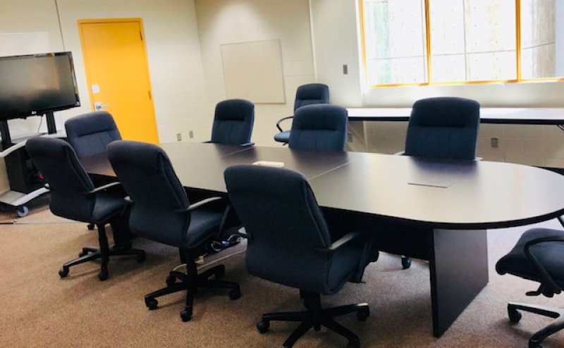 meeting boardroom with table and black chairs