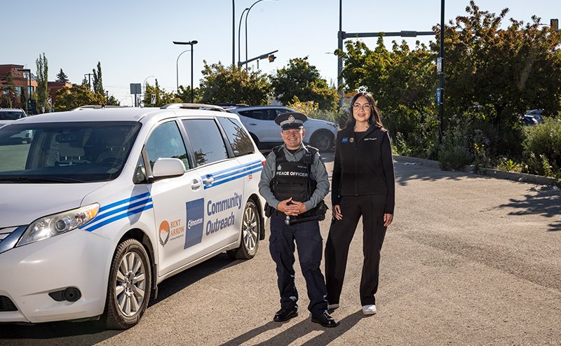 four diverse peace officers standing in front of car marked "Community Outreach"