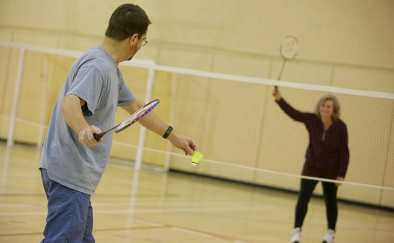 Photo of two people playing badminton.