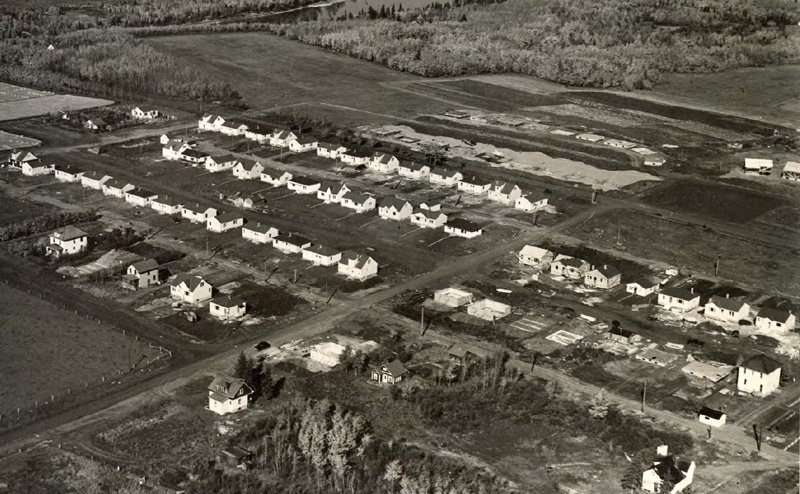 Black and white aerial photo of a housing development.