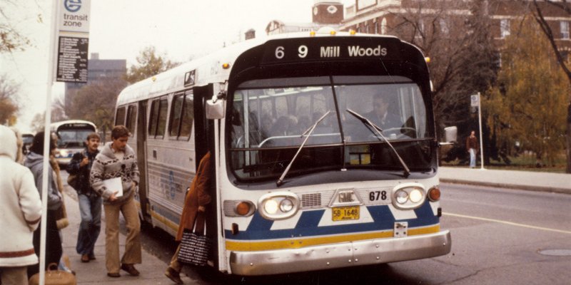 People boarding a bus in the 80s.