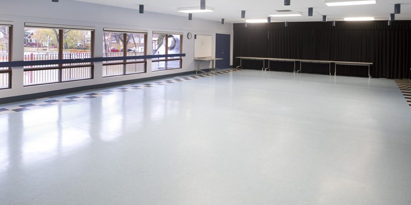 large room with wide windows and black curtain at back of room