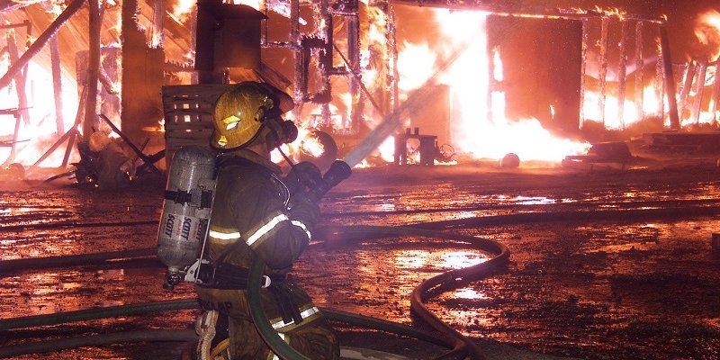 firefighter using hose on fire