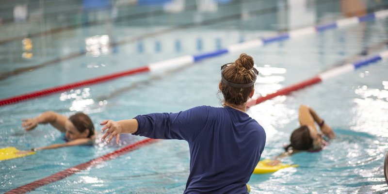person demonstrating swim with people in pool