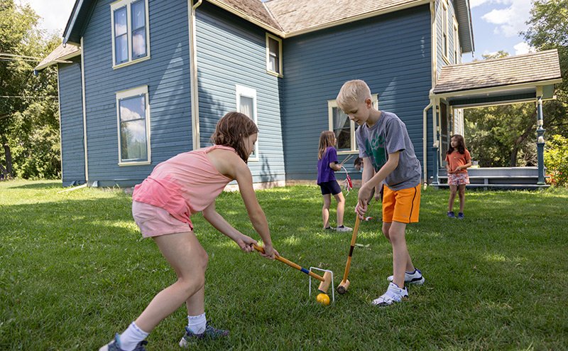children playing lawn croquet on grass