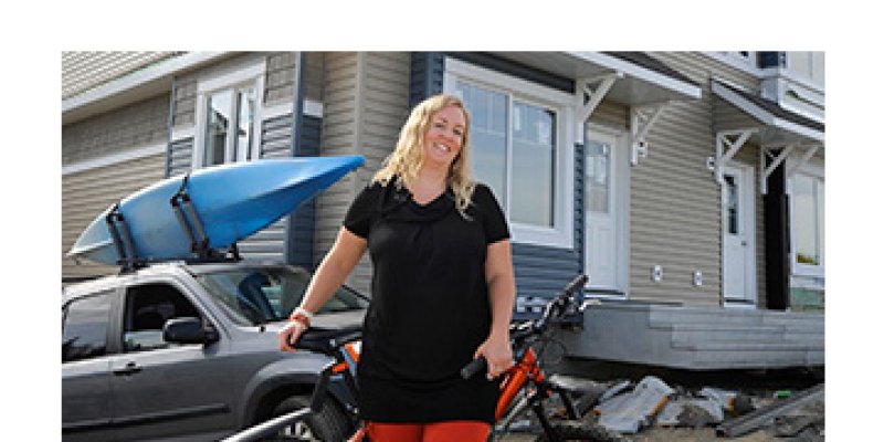 Janna posing with her bike in front of a townhome (cropped)