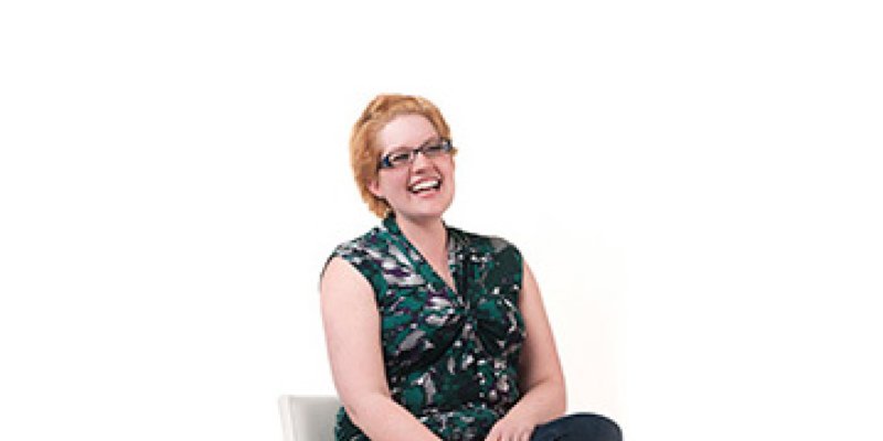 Kathryn posing seated on a chair with a white background (cropped)